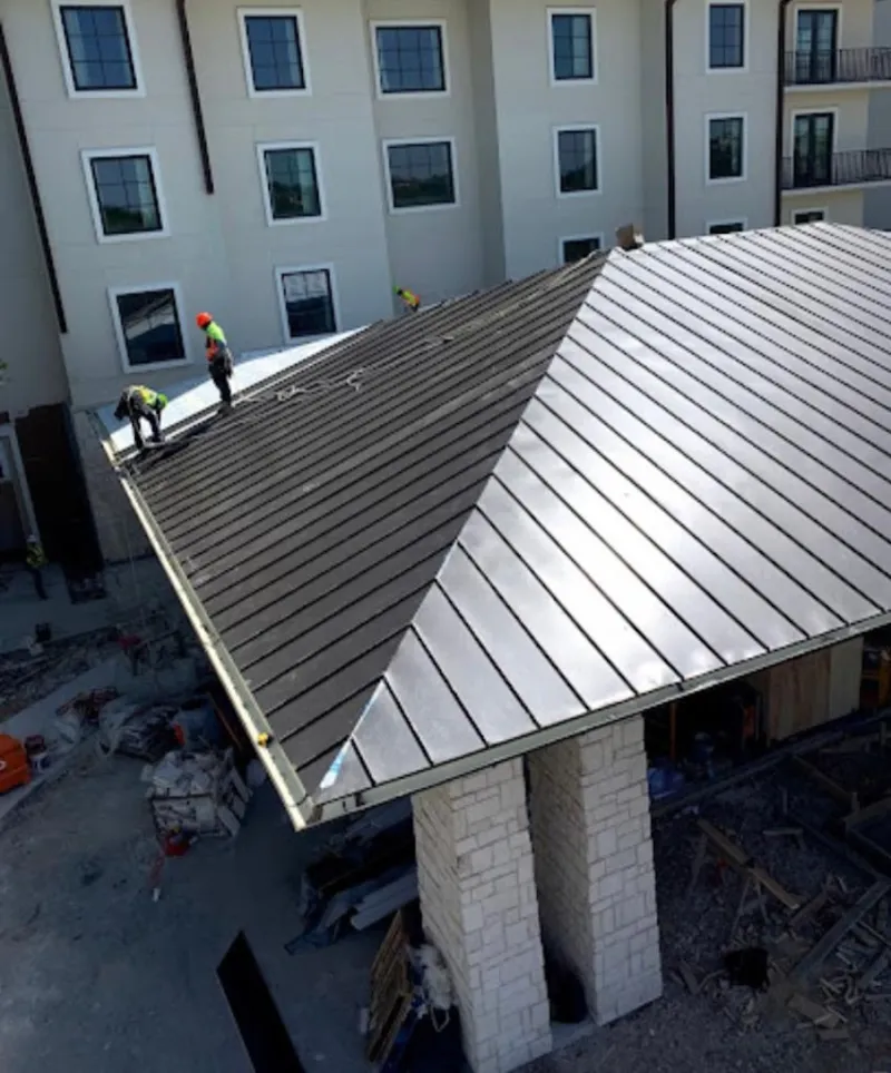 Crew installing standing seam metal roof panels on a commercial project in Breaux Bridge